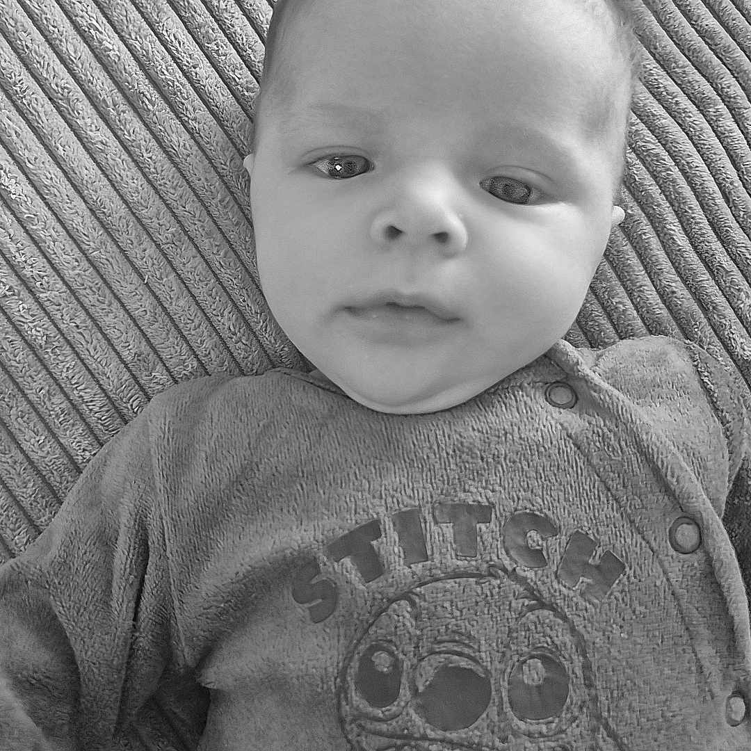 Kivers a rejoint le concours — aidez-le/la à gagner de superbes lots ! apparel, baby, black_and_white, character, child, clothing, cozy, cute, eyes, fabric, face, head, infant, lying_down, monochrome, portrait, soft_lighting, stitch, texture, young