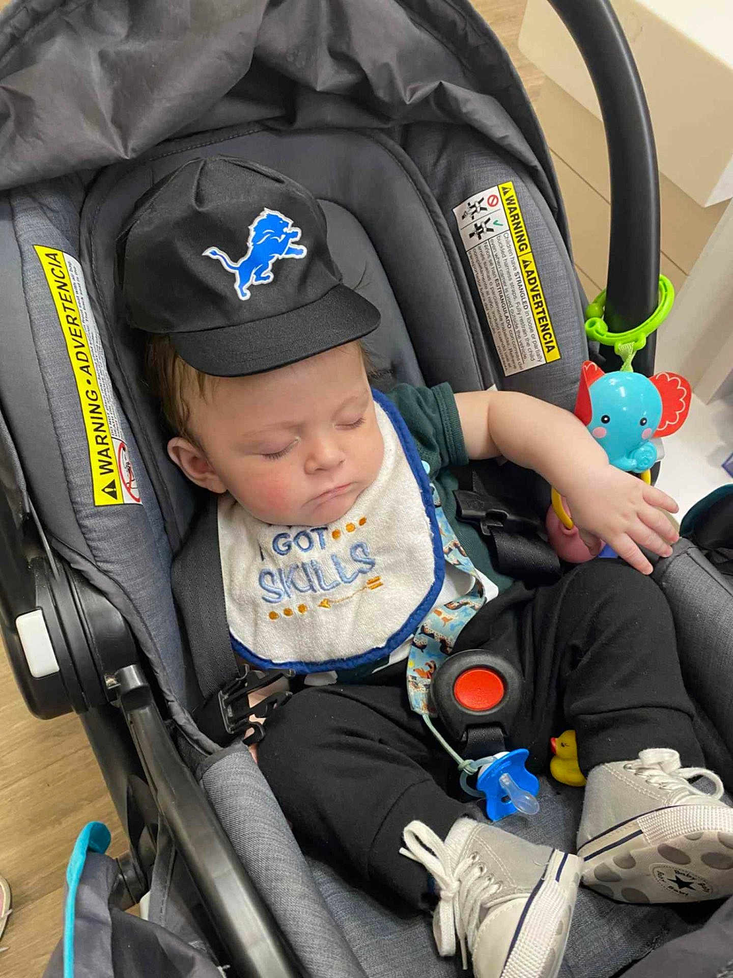 Edward joined the competition — help win amazing prizes! baby, sleeping, car_seat, cap, bib, clothing, toy, pacifier, footwear, infant, child, cute, indoor, seatbelt, black_pants, white_shoes, blue, red, yellow, peaceful