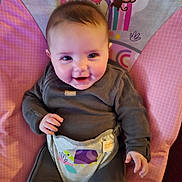 Amelia is registered to the contest to win money with this photo: baby, infant, smile, child, baby_chair, clothing, cute, happy, indoor, person, face, head, seat, toddler, colorful, pattern, monkey, rainbow, comfort, portrait