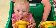 Raylynn joined the competition — help win amazing prizes! baby, child, shopping_cart, store, grocery, playful, tongue_out, pink_clothing, yellow_steering_wheel, green_cart, aisle, shelves, snacks, floor, person, fun, indoor, cute, two_children, supermarket