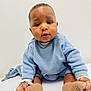 baby, blue_sweater, booties, child, clothing, curious_expression, cute, eyes, face, feet, hands, indoor, infant, portrait, sitting, skin, soft_lighting, table_surface, toddler, white_background