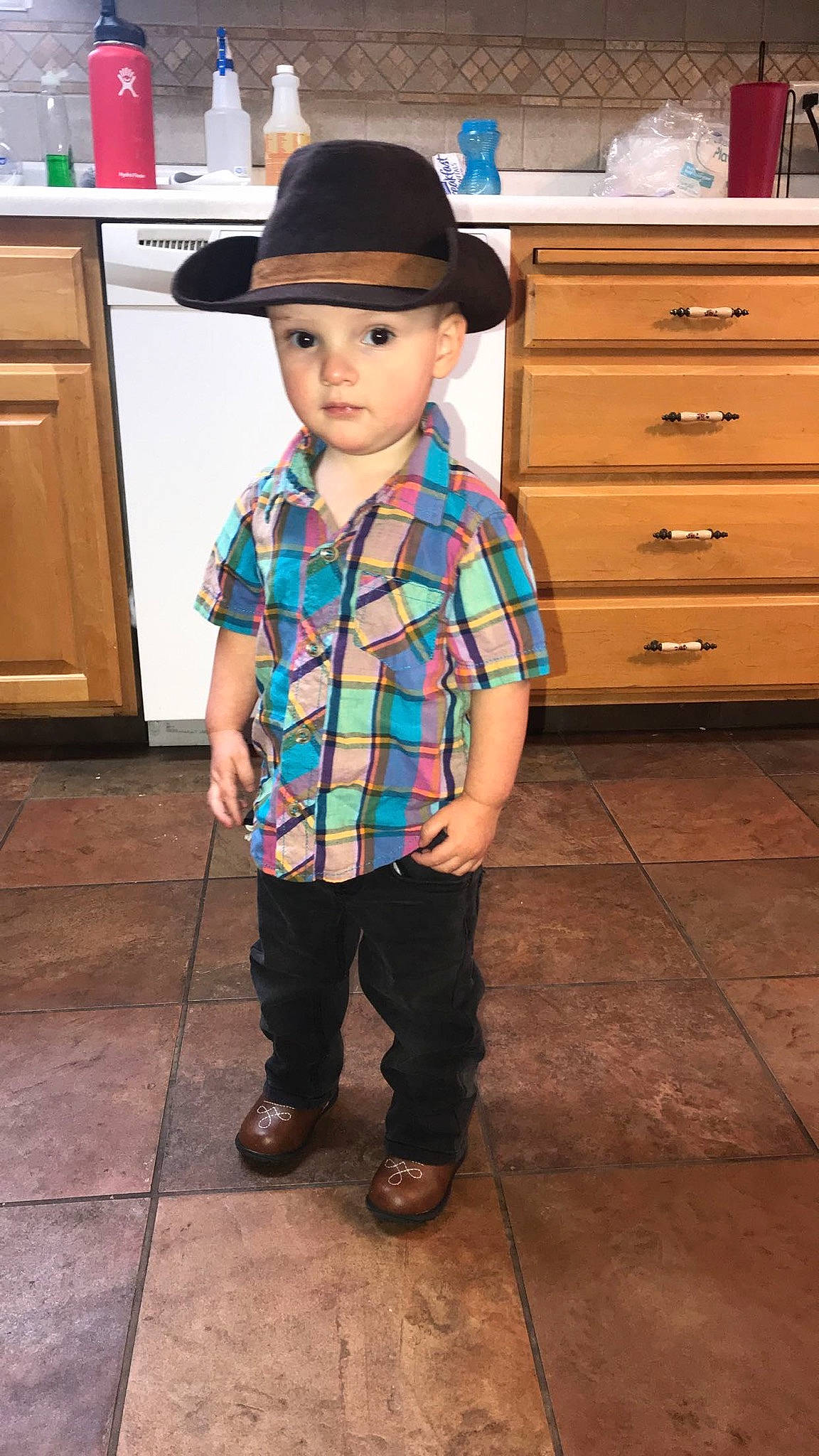 Deklyn is registered to the contest to win money with this photo: child, clothing, cool, cowboy_hat, design, fashion_accessory, footwear, hat, headgear, headwear, outerwear, pattern, person, plaid, shoe, sleeve, standing, sun_hat, t_shirt, tartan