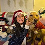 girl, dog, golden_retriever, santa_hat, christmas, holiday, smiling, plush_toy, snowman, couch, blanket, indoor, festive, child, pet, celebration, costume, happy, home, family