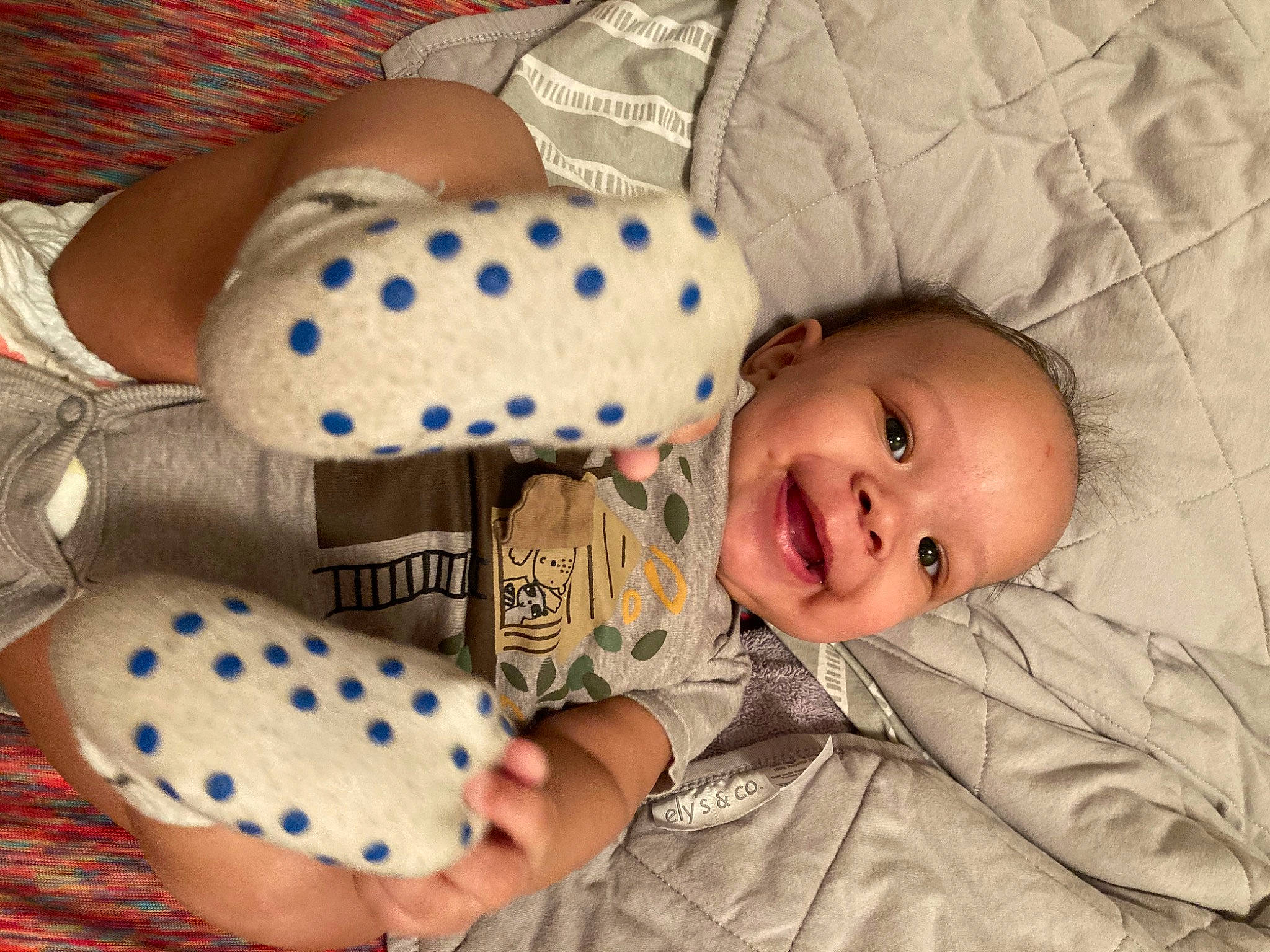 Anakin is registered to the contest to win money with this photo: baby, baby_products, baby_sleeping, baby_toddler_clothing, blue, cheek, child, clothing, comfort, happy, linens, pattern, person, polka_dot, room, sitting, skin, sleeve, smile, toddler