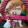 child, toddler, birthday, party, balloon, unicorn, cake, dress, white_dress, floor, table, gift_bags, toy, balloon_arch, number_balloon, hand, person, celebration, indoor, decorations