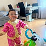 Janna a rejoint le concours — aidez-le/la à gagner de superbes lots ! child, toddler, smiling, toy, walker, indoor, floor, furniture, table, chair, curtains, couch, pillow, clothing, baby, person, happy, room, playing, home