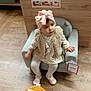 toddler, child, armchair, pink_bow, turban, furry_vest, dress, tights, shoes, flooring, wood_floor, store, price_tag, furniture, indoor, curious, seated, person, baby, cute