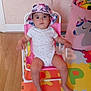 baby, child, hat, pink_chair, pink_umbrella, foam_mat, alphabet_mat, unicorn_basket, toy, indoor, floor, colorful, play_area, seated, looking_up, cute, infant, young_child, comfortable, home