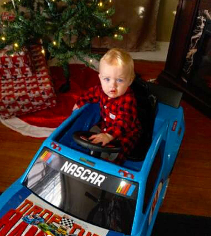 Ace is registered to the contest to win money with this photo: baby, baby_products, baby_safety, baby_toddler_clothing, box, child, christmas_decoration, christmas_tree, comfort, conifer, event, flooring, fun, holiday, lap, person, room, sitting, toddler, tree