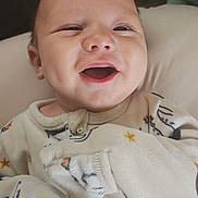 Wayne is registered to the contest to win money with this photo: baby, smiling, pajamas, infant, face, happy, cute, child, portrait, sleepwear, closeup, cozy, expression, young, person, indoors, soft, warm, cheerful, newborn