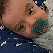 Ilyas participe au concours pour gagner de l'argent avec cette photo : baby, pacifier, face, blue, cushion, stars, infant, closeup, sleeping, child, eyes, soft_lighting, comfort, blanket, cute, indoors, portrait, young, resting, skin