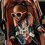 Ariyah is registered to the contest to win money with this photo: accessories, baby, baby_fashion, child, clothing, cute, cute_baby, denim_jacket, fashion, headwear, heart_shaped_glasses, indoor, infant, person, pink, portrait, seatbelt, stroller, sunglasses, toddler