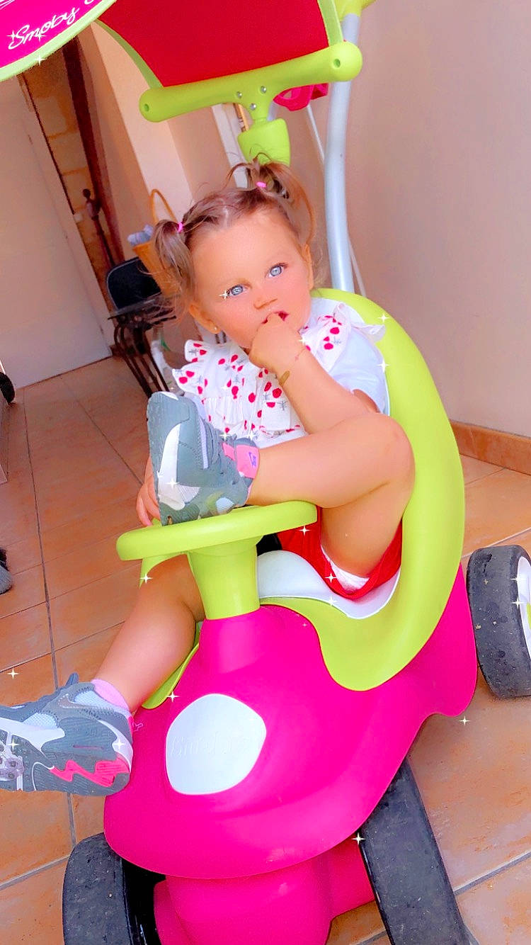 Shaily a rejoint le concours — aidez-le/la à gagner de superbes lots ! baby, baby_products, baby_toddler_clothing, carmine, chair, child, costume, event, fun, happy, human_leg, knee, lap, leisure, magenta, party_supply, person, pink, sandal, thigh
