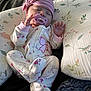 baby, infant, sleeping, pacifier, headwrap, onesie, floral_pattern, pillow, blanket, cozy, hands, feet, newborn, nursery, sleepwear, cute, peaceful, indoor, fabric, portrait