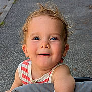 Léandre participe au concours pour gagner de l'argent avec cette photo : toddler, child, smiling, face, blue_eyes, hair, outdoor, pavement, striped_clothing, sleeveless, cute, happy, baby, person, portrait, skin, cheeks, daylight, casual, curious