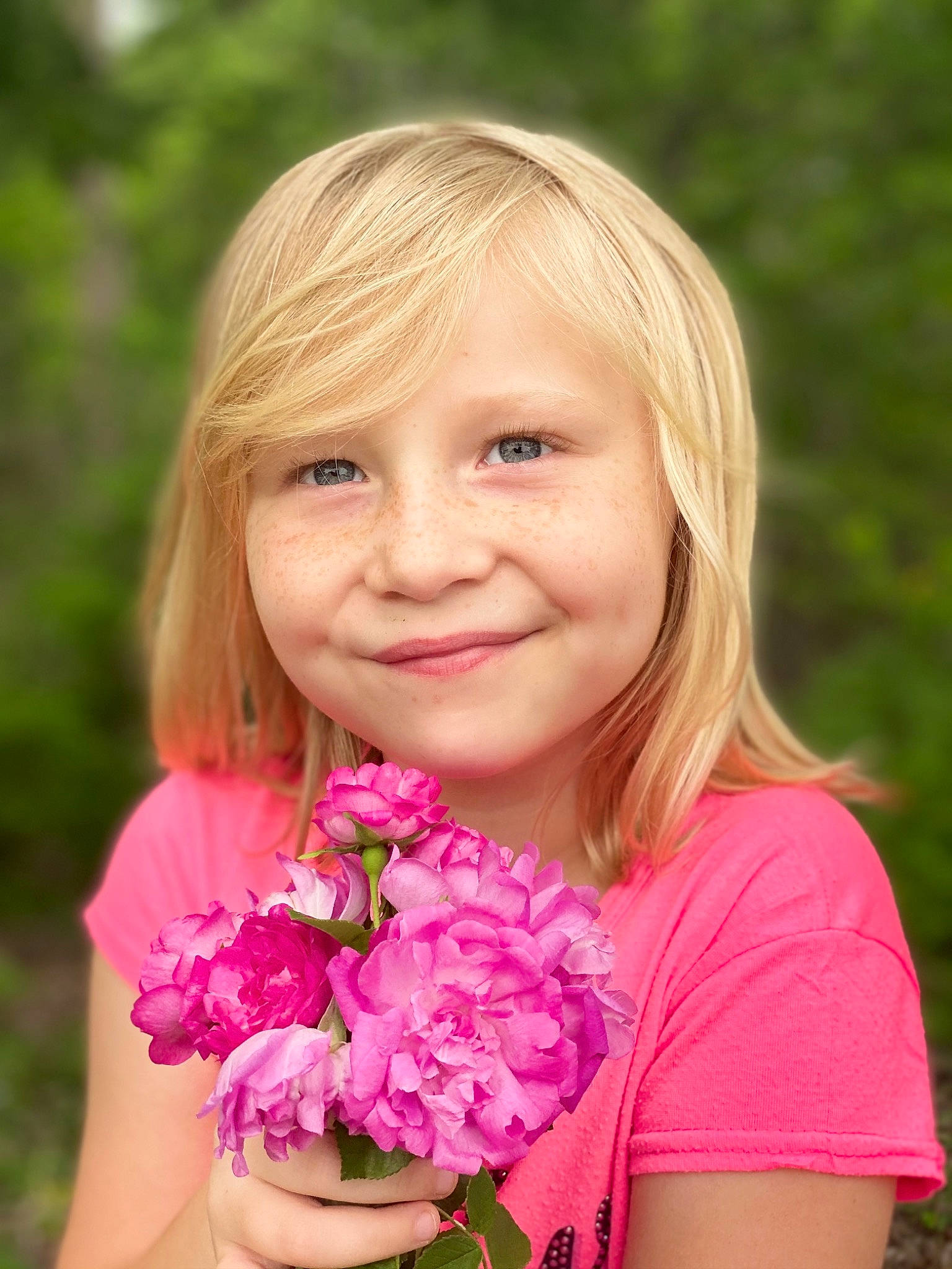 Loretta is registered to the contest to win money with this photo: beauty, blond, brown_hair, child, face, flower, flower_arranging, grass, happy, iris, joy, long_hair, magenta, people_in_nature, person, petal, pink, plant, rose, skin