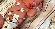 Jericho is registered to the contest to win money with this photo: newborn, baby, hospital, medical, monitoring, tubes, diaper, blanket, sleeping, infant, person, cute, fragile, healthcare, patient, bed, striped, skin, hospital_equipment, resting