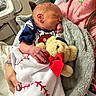 Jericho is registered to the contest to win money with this photo: newborn, baby, sleeping, blanket, teddy_bear, person, hand, hospital, robe, pink, floral, soft, cozy, infant, cute, wrapped, resting, indoor, child, portrait