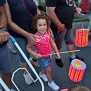 Meylia a rejoint le concours — aidez-le/la à gagner de superbes lots ! child, girl, smile, lantern, street, people, adult, summer, festival, celebration, curly_hair, pink_shirt, denim_shorts, sneakers, walking, hand, outdoor, evening, group, fun
