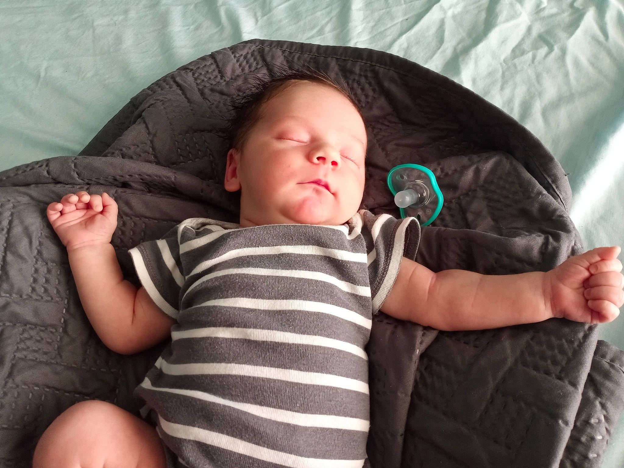 Denver is registered to the contest to win money with this photo: arm, baby, baby_toddler_clothing, cheek, comfort, eye, face, facial_expression, finger, gesture, hand, head, human_body, mammal, mouth, person, product, skin, sleeve, textile