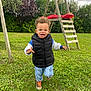 black_vest, blue_jeans, bushes, casual_clothing, child, cloudy_sky, curly_hair, daytime, grass, greenery, happy, lawn, nature, outdoor, playground, running, sneakers, swing_set, toddler, wooden_structure