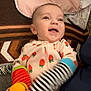 Presley joined the competition — help win amazing prizes! baby, blanket, child, clothing, cute, face, happy, indoor, infant, laughing, lying_down, mittens, patterned, person, portrait, sleeper, smiling, strawberry, striped, textile