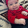 Presley is registered to the contest to win money with this photo: baby, bright_colors, child, closeup, cozy, cushion, cute, fabric, happy, headwear, indoors, infant, patterned_cushion, person, portrait, red_headband, red_shirt, relaxed, small_hands, smiling