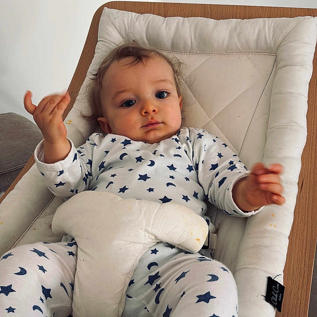 Eli a rejoint le concours — aidez-le/la à gagner de superbes lots ! baby, baby_seat, blue, child, clothing, cushion, cute, expression, face, hands, indoor, infant, moon, pajamas, portrait, relaxed, stars, white, wood, young