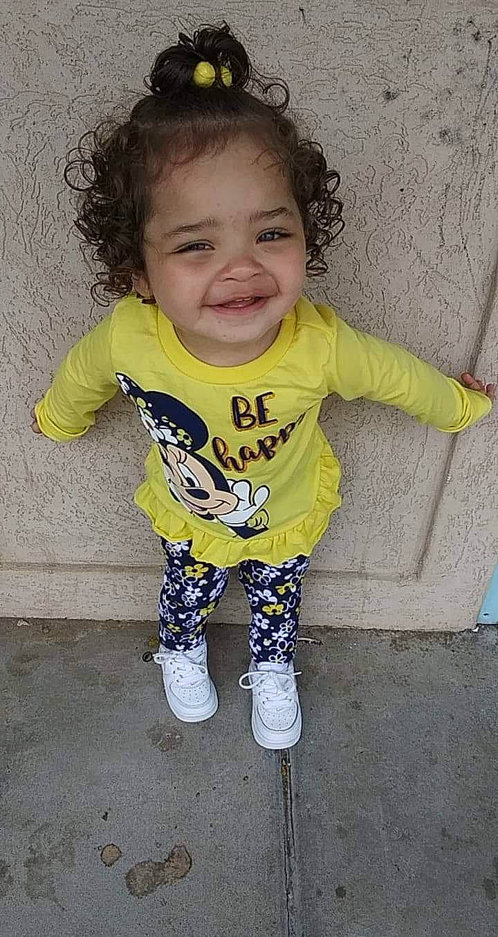 Aviana is registered to the contest to win money with this photo: arm, baby_toddler_clothing, cheek, face, facial_expression, finger, gesture, hand, happy, head, human_body, iris, joy, outerwear, person, skin, sleeve, smile, t_shirt, toddler