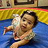 Asha joined the competition — help win amazing prizes! baby, blue_mat, child, colorful_mat, curly_hair, cute, door, exploring, floor, indoor, infant, looking_up, photograph, pink_bow, play_area, portrait, red_mat, tummy, wooden_wall, yellow_mat