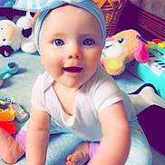 Alina joined the competition — help win amazing prizes! baby, child, blue_eyes, headband, toy, indoor, carpet, smiling, happy, couch, basket, plush_toy, foot, hand, white_shirt, colorful_pants, play, infant, person, room