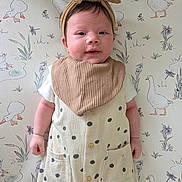 Ellie is registered to the contest to win money with this photo: baby, infant, headband, bow, polka_dot, outfit, blanket, pattern, goose, animal_illustration, cute, portrait, child, young, smile, face, skin, hand, lying_down, background