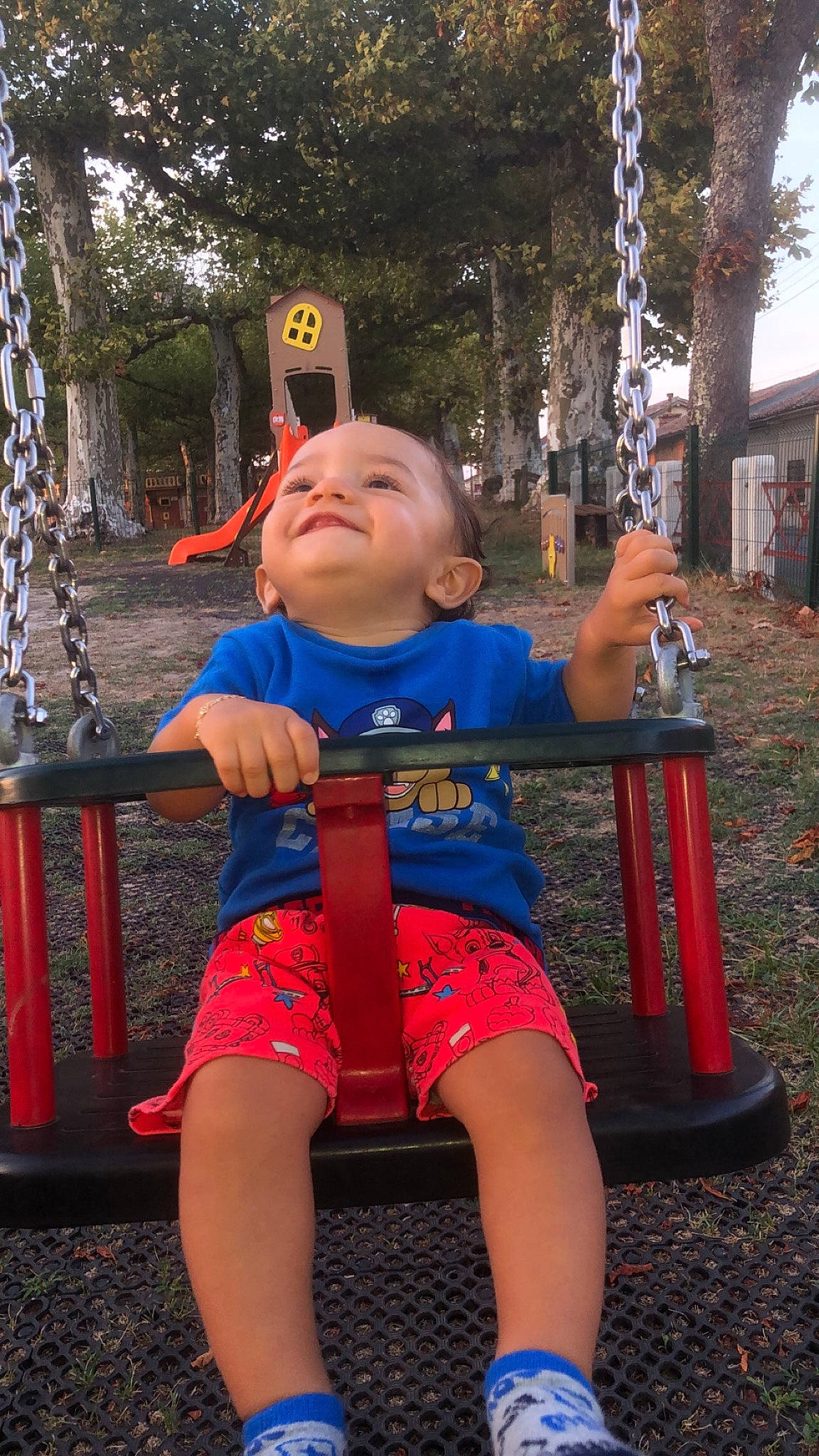 Kaylan participe au concours pour gagner de l'argent avec cette photo : child, city, electric_blue, facial_expression, fun, happy, leaf, leg, leisure, outdoor_play_equipment, person, pink, plant, playground, public_space, recreation, shorts, standing, swing, toddler