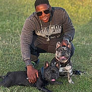 Oreo is registered to the contest to win money with this photo: man, dog, french_bulldog, grass, outdoor, sunglasses, smiling, casual_clothing, collar, chain, watch, ring, pet, animal, happy, daylight, nature, playing, friendship, portrait