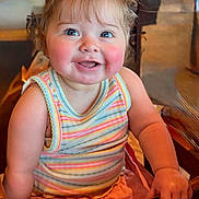 Ella Reign is registered to the contest to win money with this photo: baby, background, chair, cheerful, child, closeup, colorful_clothing, eyes, face, hair_bows, happy, indoor, photography, ponytails, portrait, rosy_cheeks, sitting, smiling, striped_outfit, toddler