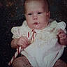 baby, infant, candy_cane, white_clothing, frilly_outfit, serious_expression, sitting, portrait, indoor, child, cute, small_hands, young, face, head, skin, person, vintage_photo, dark_background, closeup