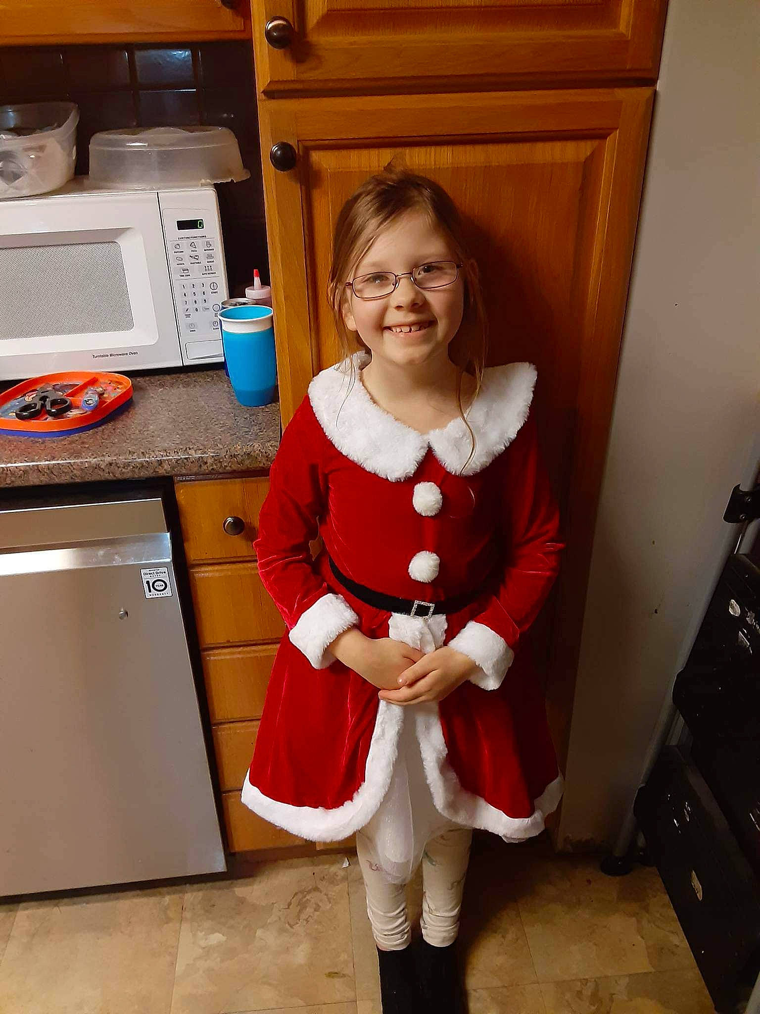 Luna is registered to the contest to win money with this photo: cabinetry, cooking, cooktop, drawer, flooring, gas_stove, home_appliance, human_leg, joy, kitchen, kitchen_appliance, kitchen_stove, knee, lap, microwave_oven, person, sleeve, smile, sock, standing