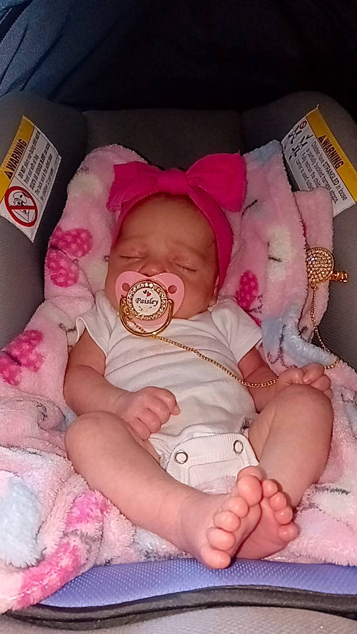 Paisley Grace is registered to the contest to win money with this photo: arm, baby, baby_products, baby_sleeping, baby_toddler_clothing, cheek, child, comfort, eye, finger, hand, head, human_body, linens, person, pink, room, sitting, skin, textile