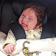 Tiana participe au concours pour gagner de l'argent avec cette photo : baby, smiling, happy, car_seat, blanket, tiger_print, infant, child, cute, clothing, indoors, portrait, face, hair, hand, cozy, seatbelt, baby_toy, pacifier, comfort