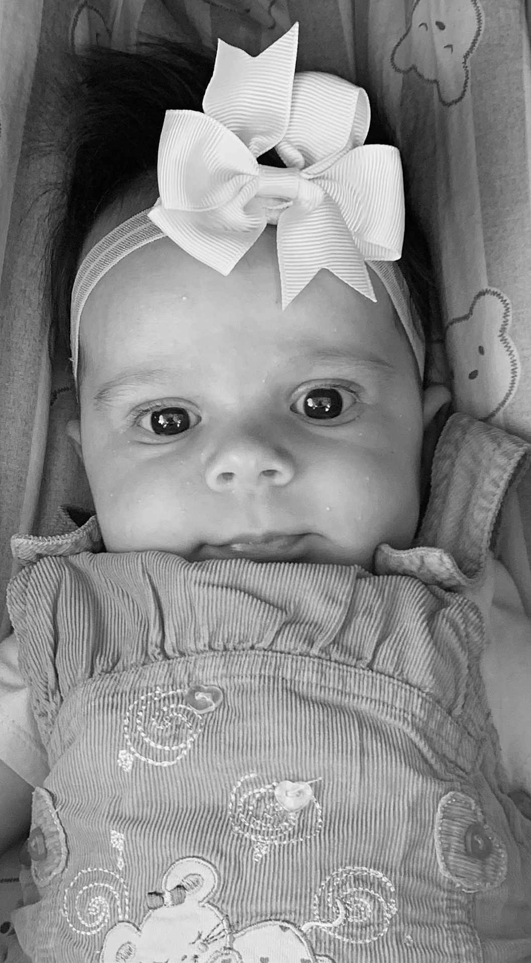 Cléophée participe au concours pour gagner de l'argent avec cette photo : baby, black_and_white, blanket, bow, child, close_up, clothing, cute, eyes, fabric, face, headband, infant, lying_down, pattern, portrait, smiling, soft, texture, young