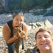 Basile participe au concours pour gagner de l'argent avec cette photo : person, man, woman, cat, outdoor, river, rocks, bridge, sunlight, nature, smiling, selfie, pet, animal, casual, leisure, greenery, tattoo, sunglasses, happy