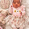 Jaelani is registered to the contest to win money with this photo: baby, newborn, infant, child, portrait, pink, headwrap, bow, floral_dress, tutu, blanket, teddy_bear, stuffed_animal, flowers, milestone_sign, one_week_old, lying_down, indoor, soft_lighting, cute