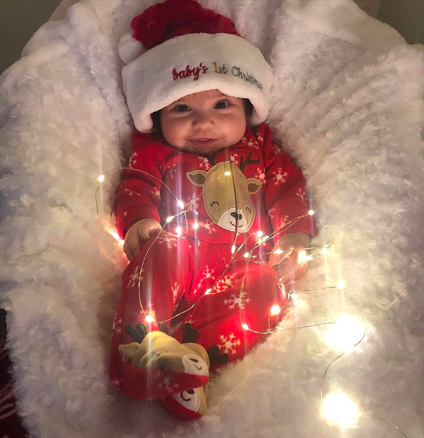 Lucianna is registered to the contest to win money with this photo: baby_toddler_clothing, cap, christmas_decoration, christmas_eve, christmas_ornament, event, face, fun, fur_clothing, happy, headgear, headwear, holiday, holiday_ornament, jacket, ornament, person, red, santa_claus, sleeve