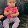Ariyah is registered to the contest to win money with this photo: baby, black_leather_couch, casual, child, clothing, comfortable, curious_expression, cute, furniture, hand, home, indoor, infant, lavender_pants, person, pink_shirt, portrait, sitting, socks, young_child