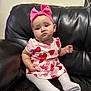 baby, casual, child, comfortable, curious_expression, cute, dress, furniture, headband, heart_pattern, indoor, infant, leather_couch, pink_bow, portrait, sitting, small_hands, soft_lighting, white_tights, young_child