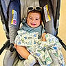 Nathan joined the competition — help win amazing prizes! baby, car_seat, blanket, dinosaur_pattern, sunglasses, smile, happy, infant, child, cute, feet, socks, clothing, indoor, floor, person, portrait, seat, headwear, comfort