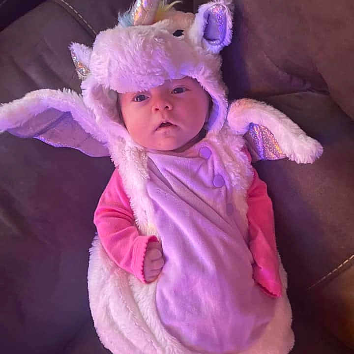 Genevieve is registered to the contest to win money with this photo: baby, baby_toddler_clothing, child, costume_hat, ear, event, fur, hair_accessory, head, headband, headgear, headpiece, human_body, magenta, mythical_creature, pink, purple, sleeve, toddler, violet