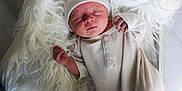 Saint is registered to the contest to win money with this photo: newborn, baby, sleeping, infant, knitwear, hat, blanket, fur, cozy, soft_texture, peaceful, portrait, child, indoors, cute, resting, sleep, small_hands, clothing, warm