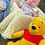 Saint joined the competition — help win amazing prizes! baby, blanket, plush_toy, winnie_the_pooh, eeyore, grass, outdoor, child, smiling, knitted_blanket, cute, toy, person, infant, happy, nature, lying_down, soft_toy, playtime, casual_clothing