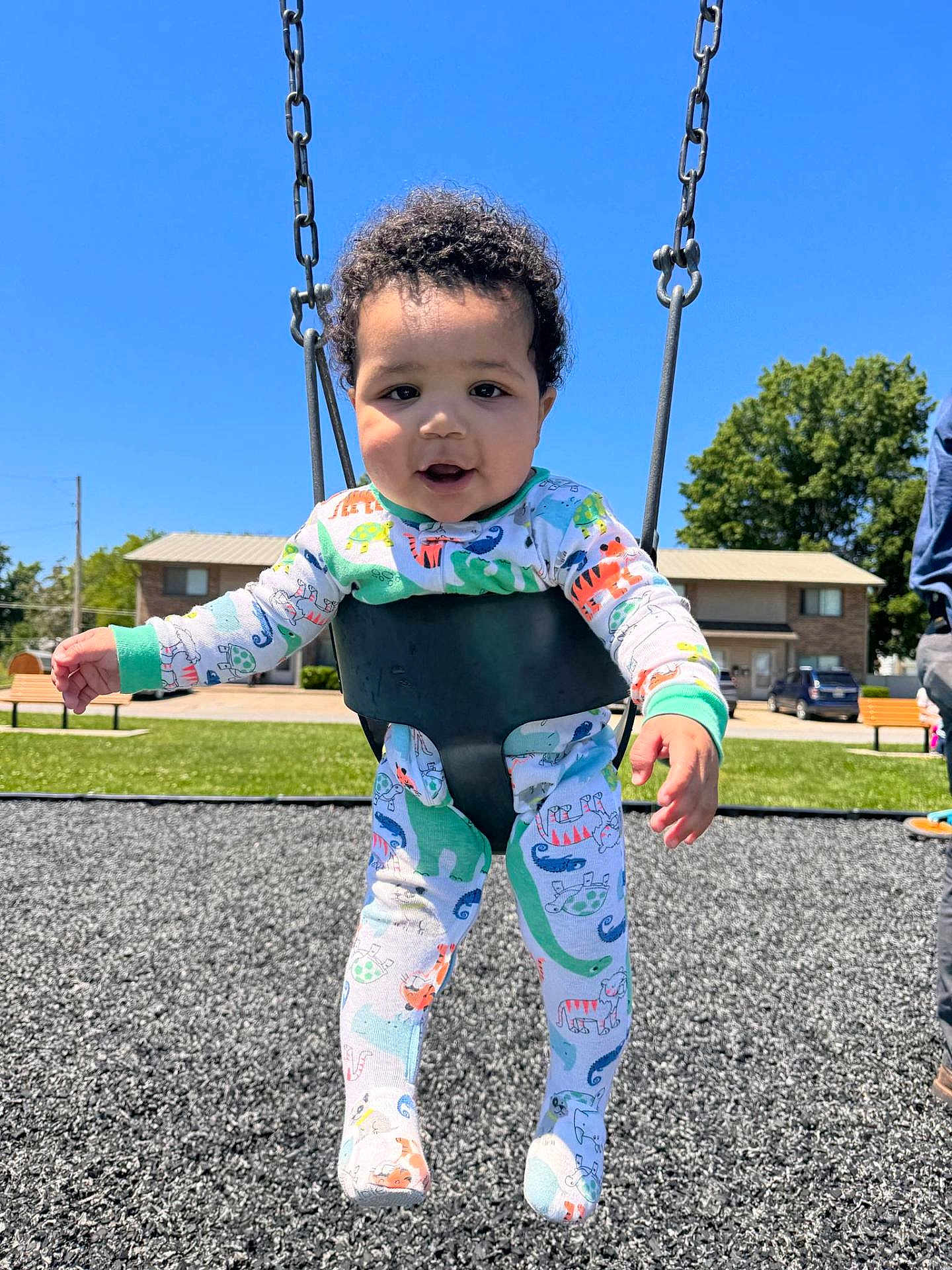 Kingston joined the competition — help win amazing prizes! toddler, child, swing, playground, outdoor, sunny, blue_sky, grass, trees, pajamas, curly_hair, happy, smiling, daytime, residential_area, bench, person, fun, baby, park